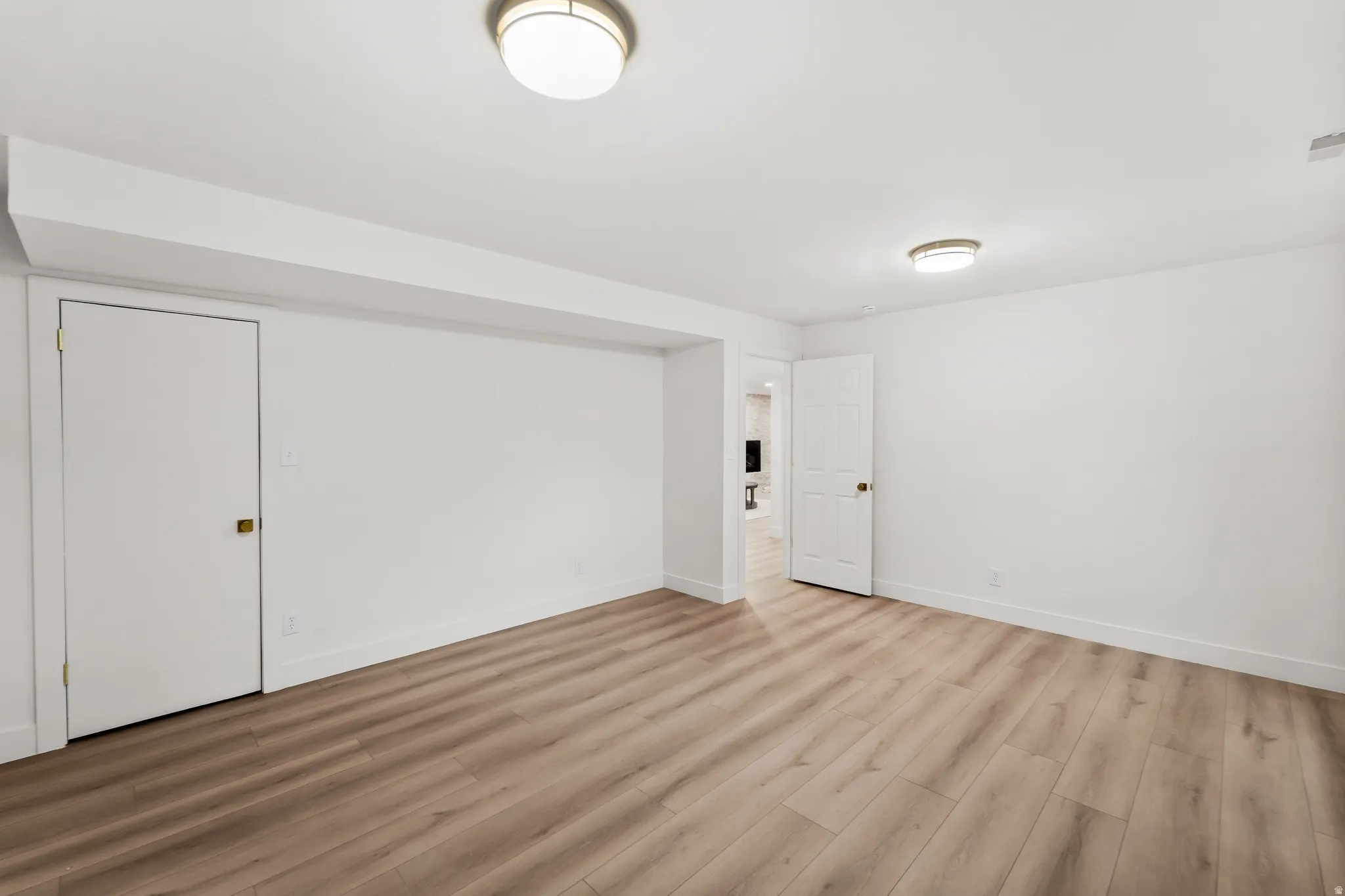 Recessed lighting, wood-finish flooring, white doors, and white trim