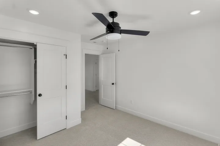 Recessed lighting, ceiling fan with light fixture, white interior doors, and neutral carpeting