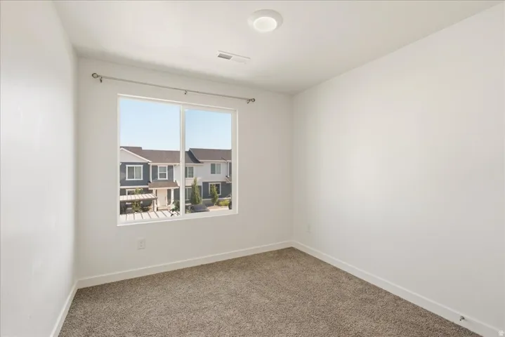Bright room with neutral wall paint, overhead flush-mount lighting, and wall-to-wall carpeting
