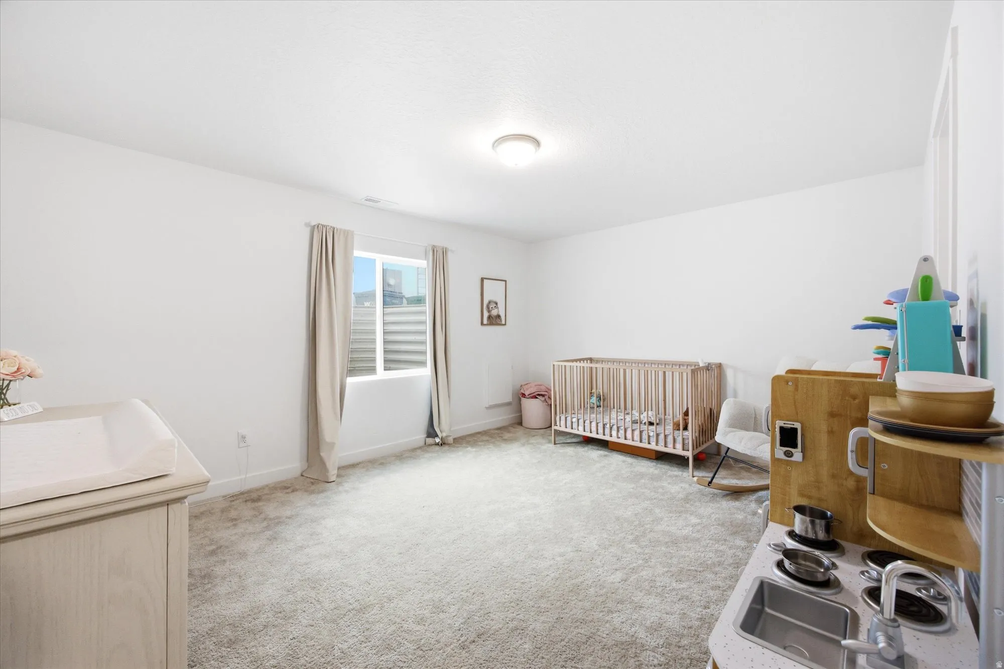 Recessed ceiling lighting illuminates the carpeted flooring and white walls