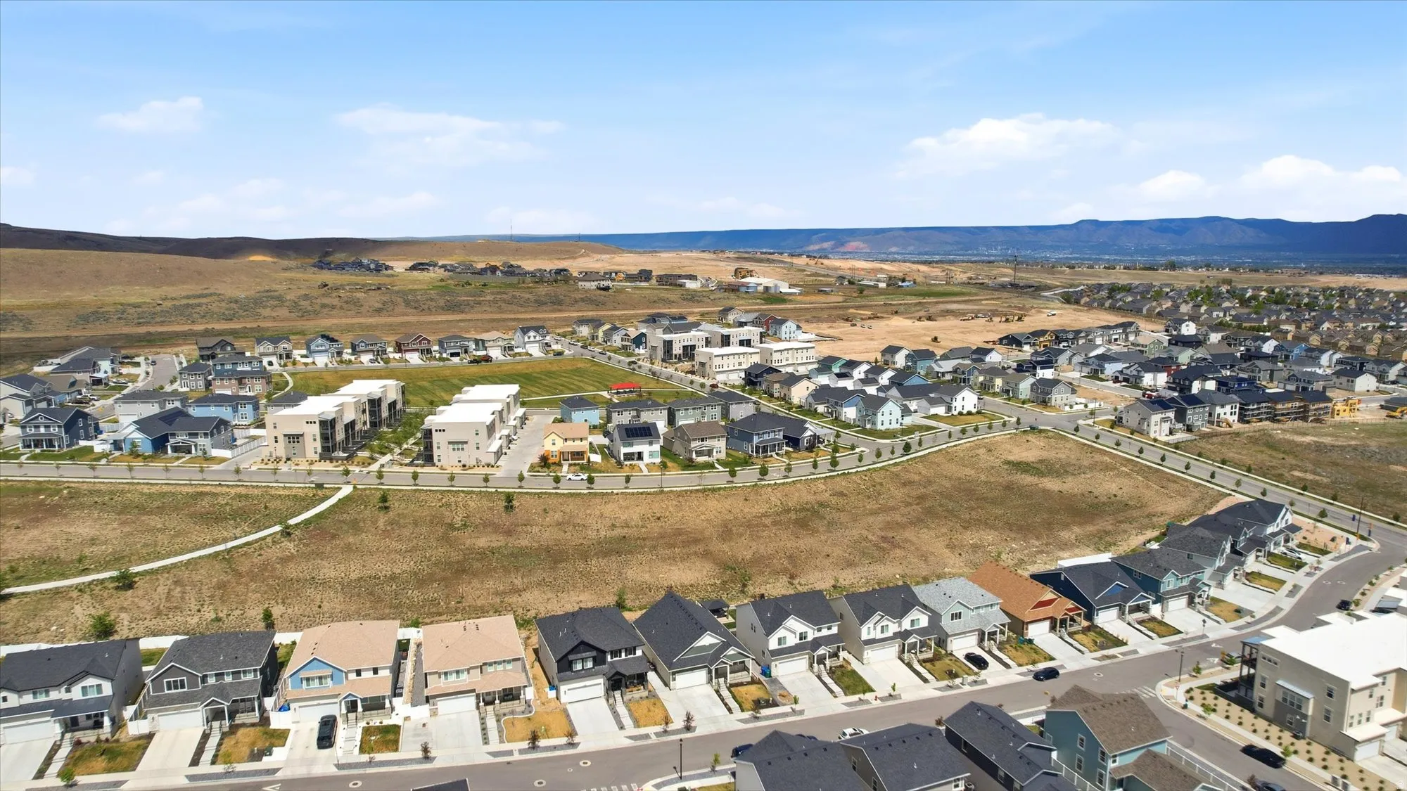 Residential development featuring a variety of architectural styles, paved streets, and undeveloped open land