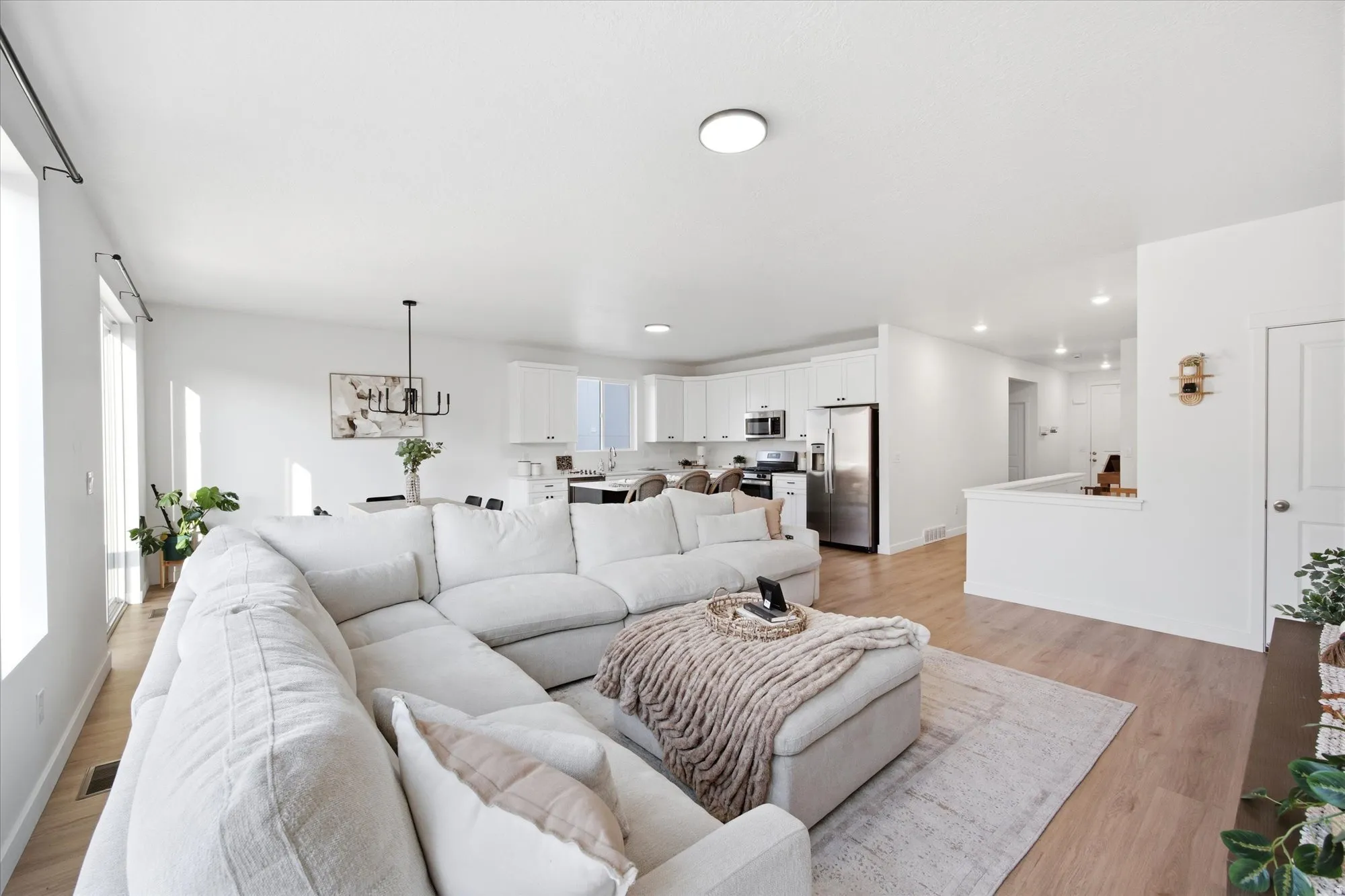Open-concept living area featuring light wood-finish flooring, white walls, and recessed lighting