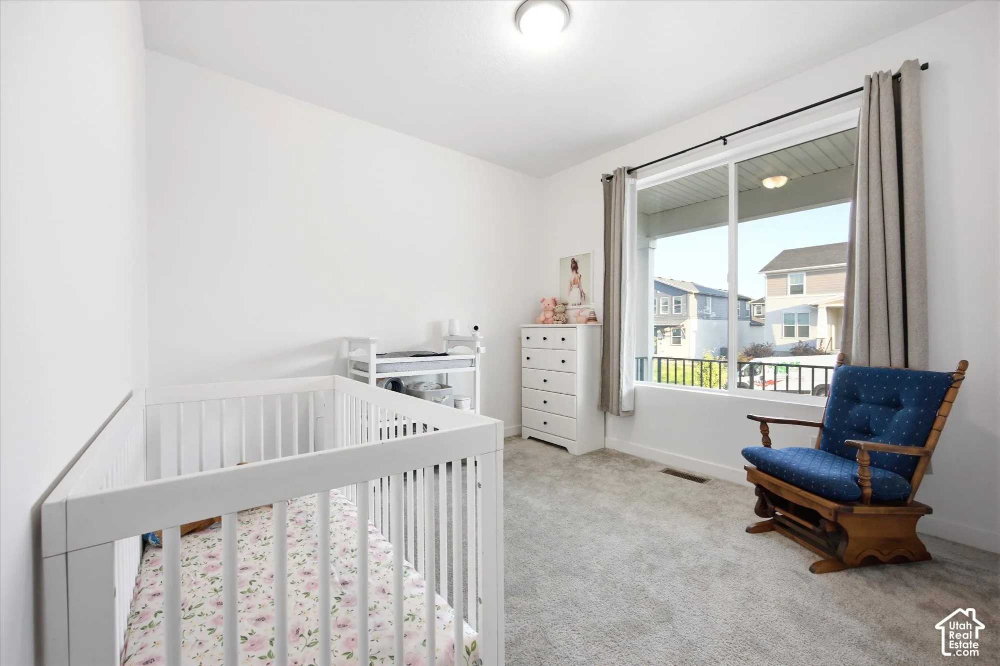 Bright interior space with light-colored carpeting, white wall finishes, and a large window