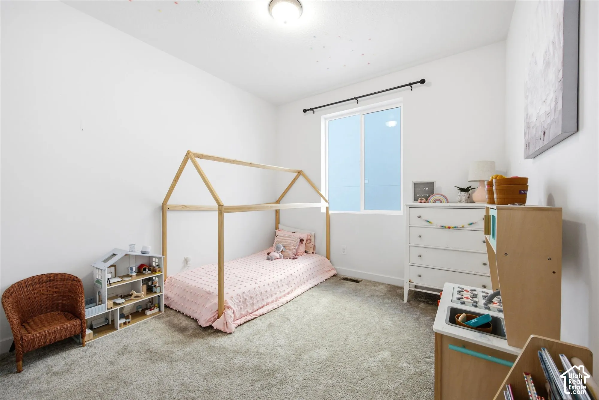 White walls, neutral carpeting, and a window with a black rod