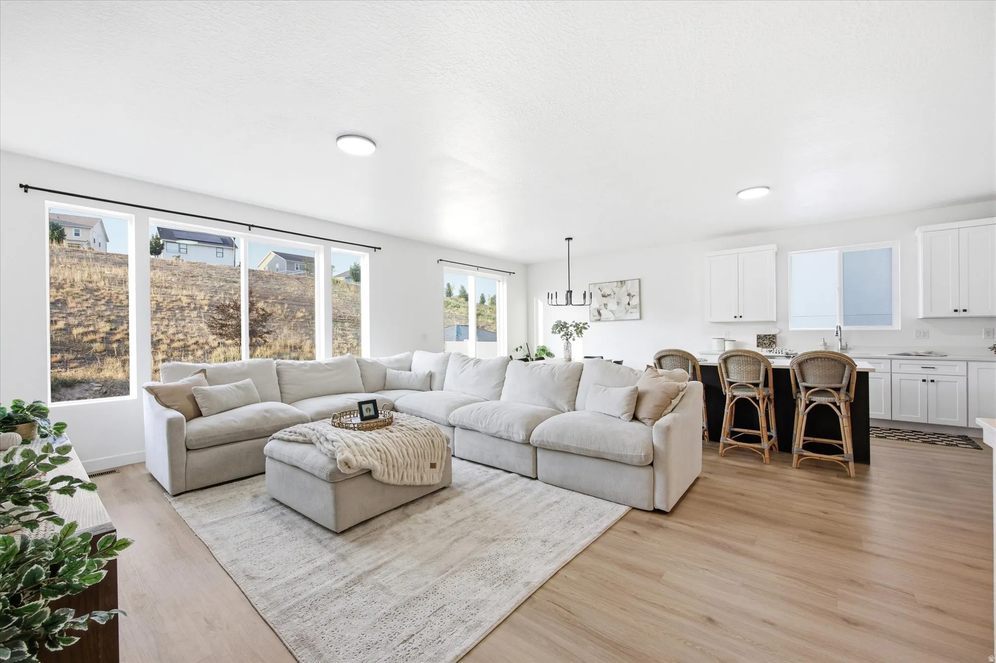 Open-concept living space featuring wood-finish flooring, white walls, and recessed lighting