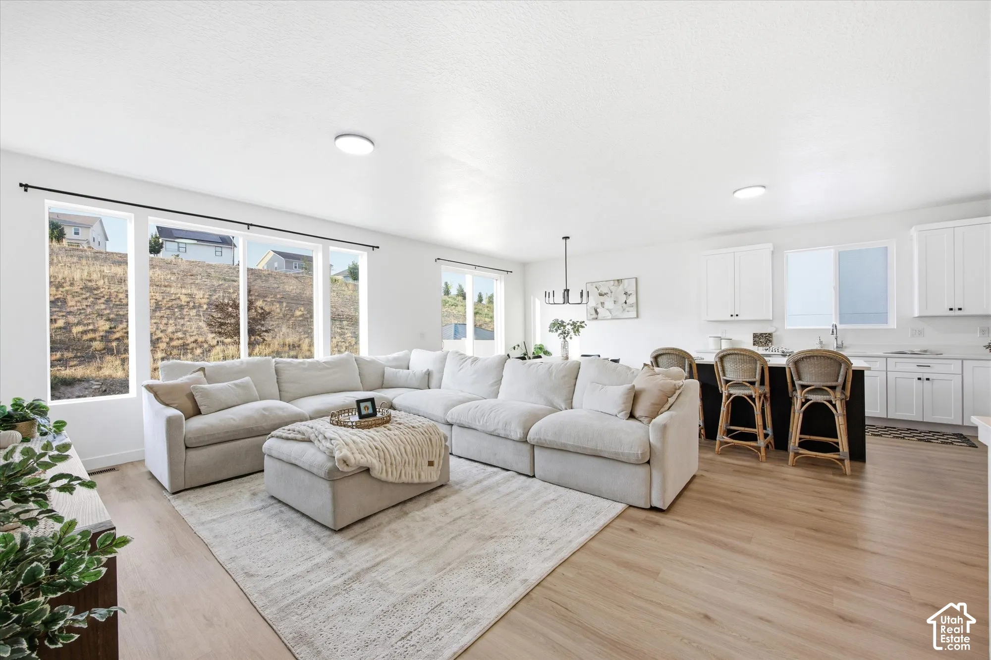 Open-concept living space featuring wood-finish flooring, white walls, and recessed lighting