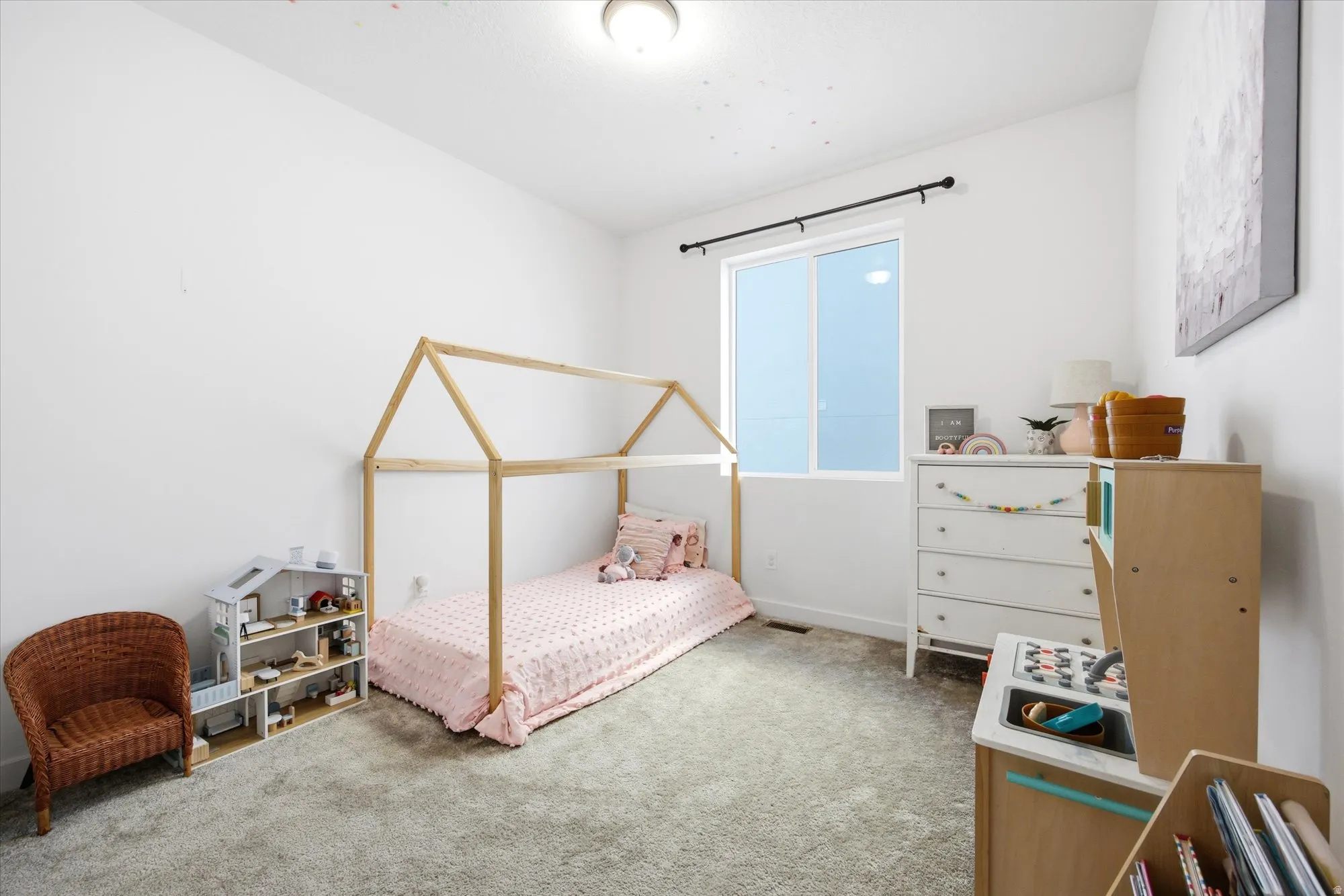 White walls, neutral carpeting, and a window with a black rod