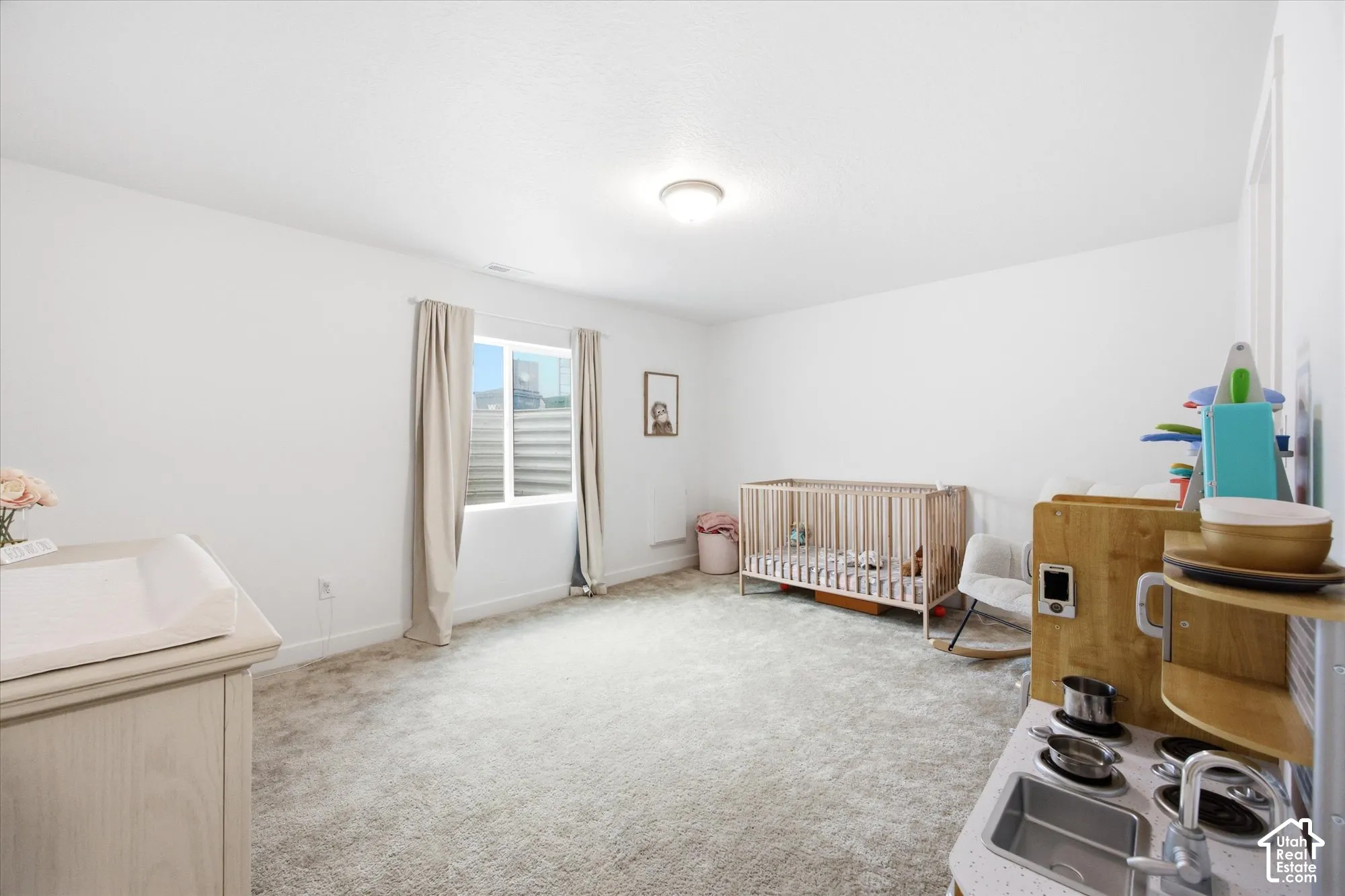 Recessed ceiling lighting illuminates the carpeted flooring and white walls