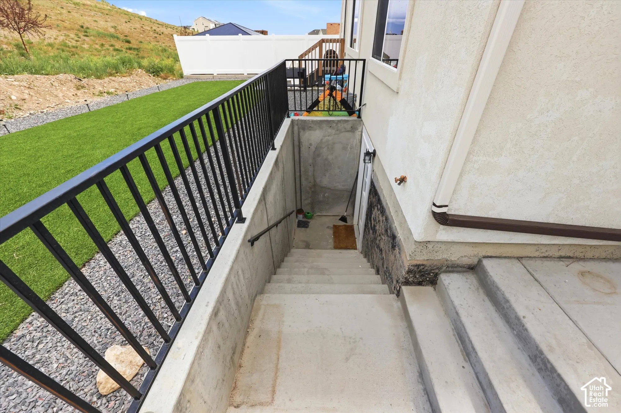 Concrete exterior stairs with metal railings, leading to a lower level entrance