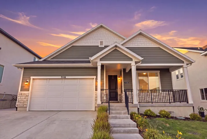 Contemporary exterior featuring a covered front porch, integrated garage, and concrete walkway