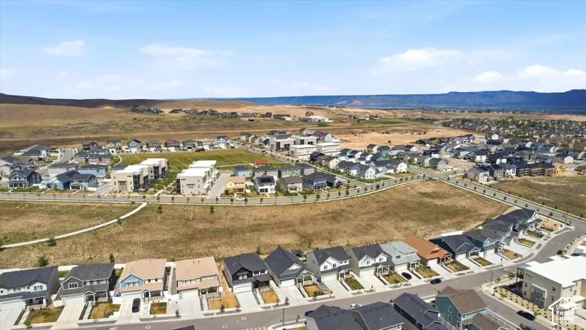 Residential development featuring a variety of architectural styles, paved streets, and undeveloped open land