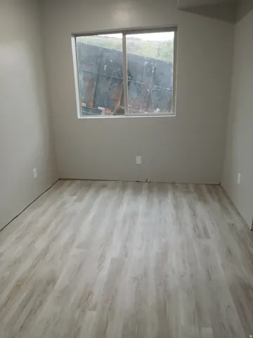 Neutral wall tones with wood-finish flooring and a large window
