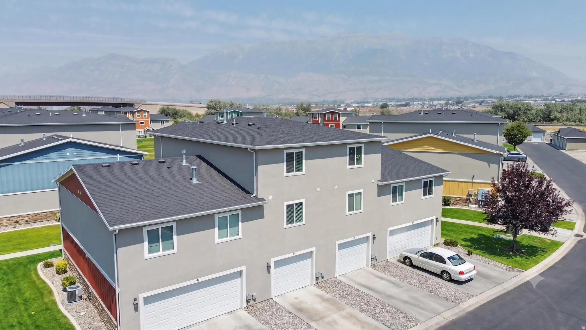Multi-story exterior with light gray stucco and dark gray roof