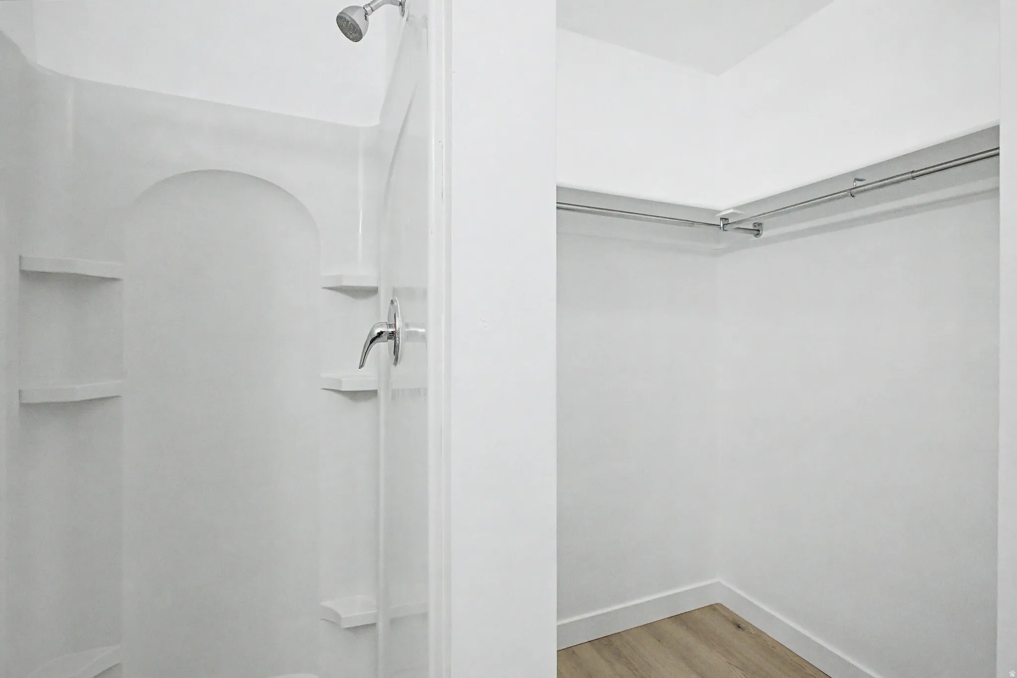Walk-in shower with integrated shelving and chrome fixtures