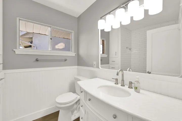 White shaker-style vanity with integrated sink and brushed nickel fixtures