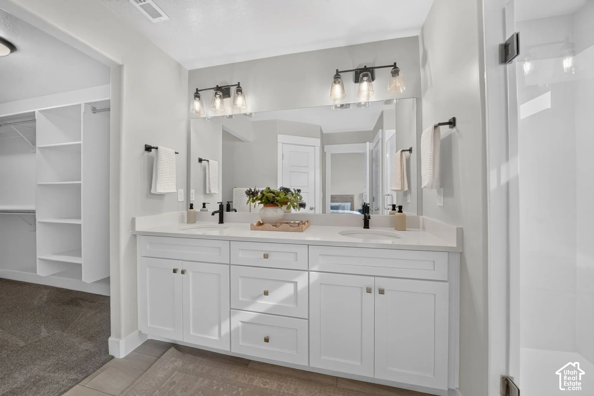 Dual sink vanity with white cabinetry and integrated sinks, complemented by matte black fixtures