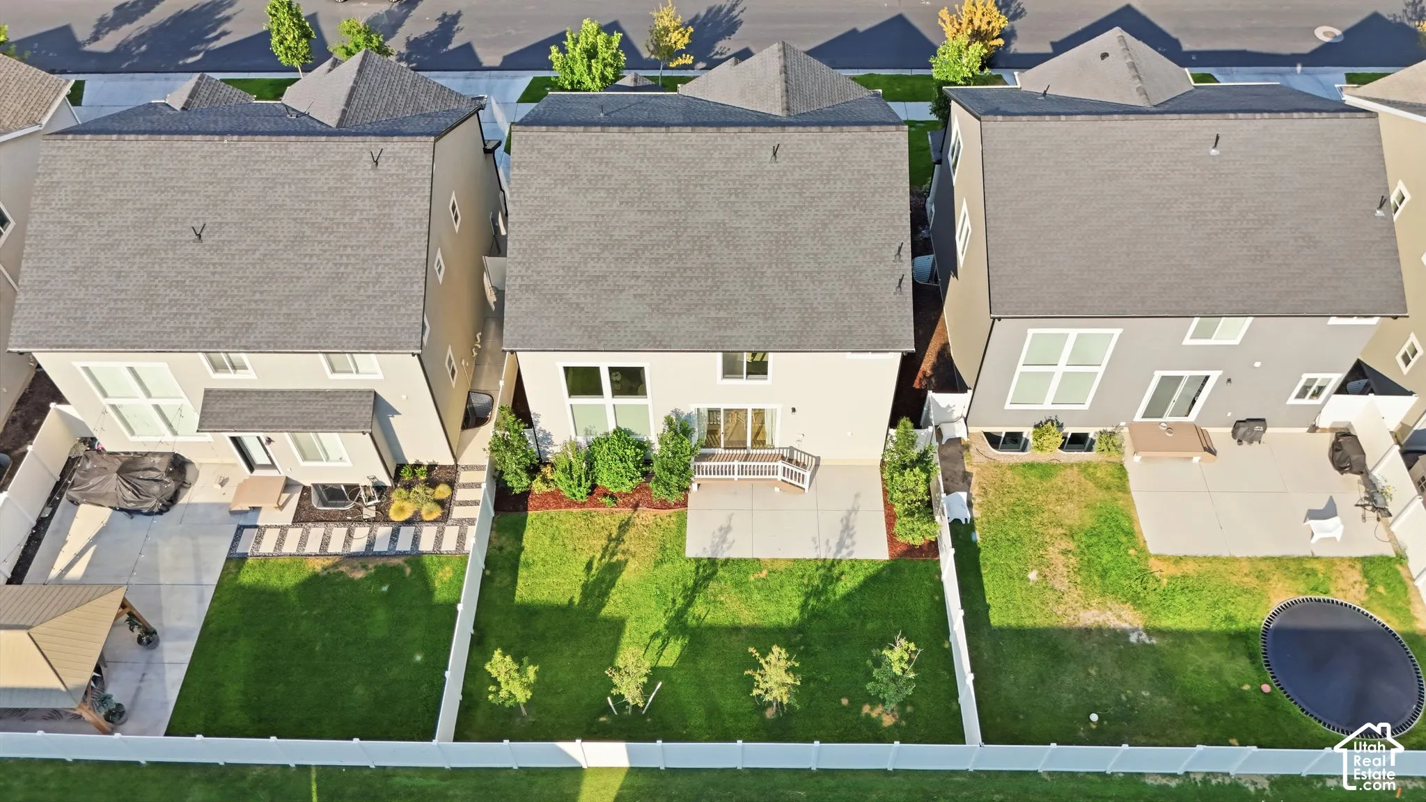 Manicured lawn, mature trees, and a spacious concrete patio