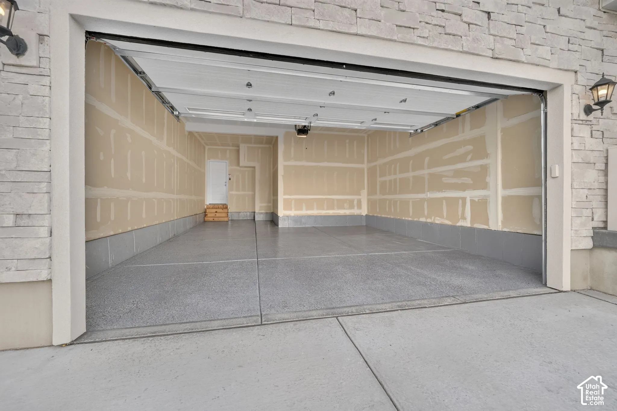 Spacious garage with an epoxy-coated concrete floor and stone facade accents
