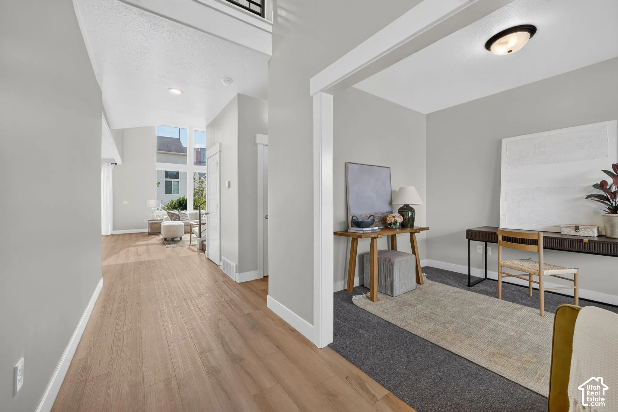 Wood-finish flooring, high ceilings, large windows, recessed lighting, and a neutral wall color