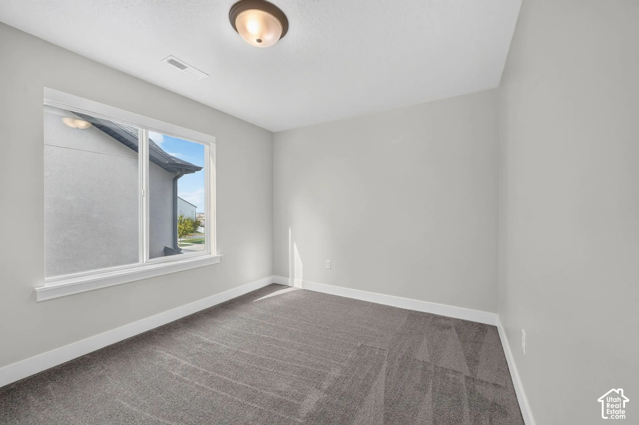 Neutral color palette, window with white trim, recessed lighting, and gray carpet