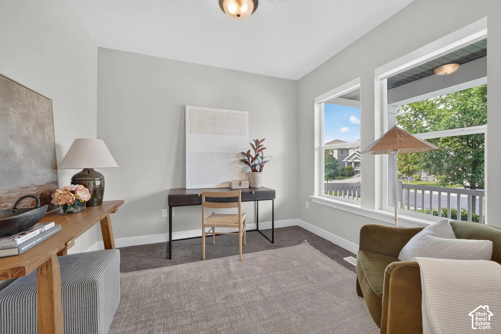 Bright room featuring two large windows, neutral wall tones, and carpeted flooring