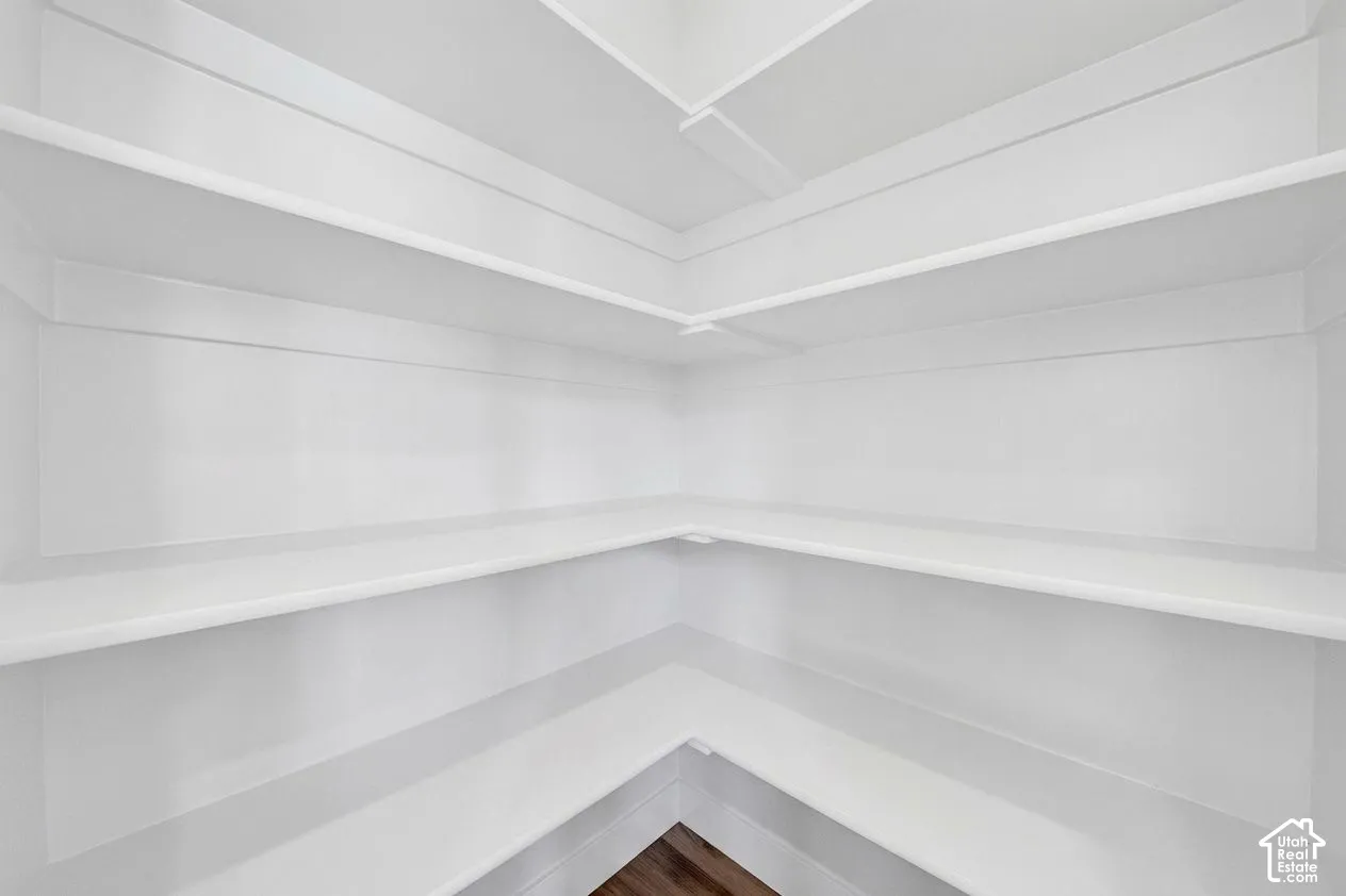 Built-in shelving with multiple levels, bright white finish, and wood-finish flooring