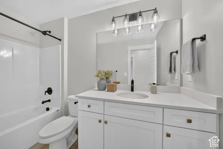 White vanity with a solid surface countertop, rectangular undermount sink, and matte black faucet