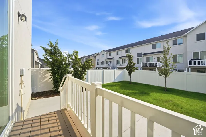 Private outdoor space featuring a composite deck, white railing, and a grass area