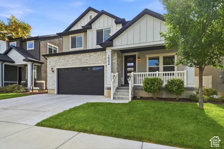Contemporary exterior with stone facade accents, covered front porch, and a two-car garage
