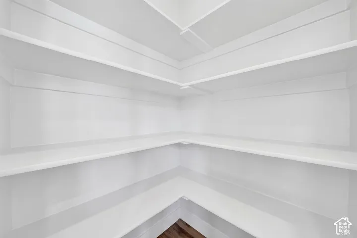 Built-in shelving with multiple levels, bright white finish, and wood-finish flooring