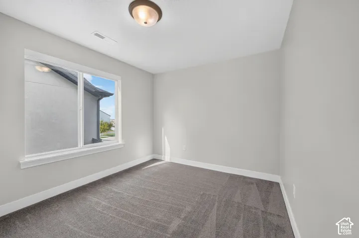 Neutral color palette, window with white trim, recessed lighting, and gray carpet