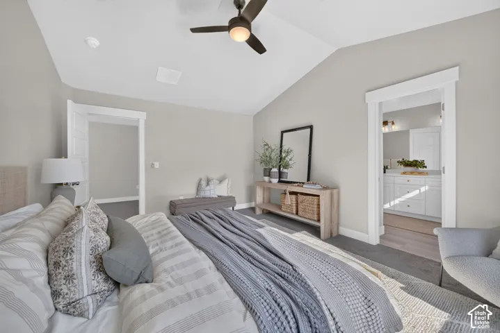 Vaulted ceiling with a ceiling fan, light gray wall paint, and gray carpeting