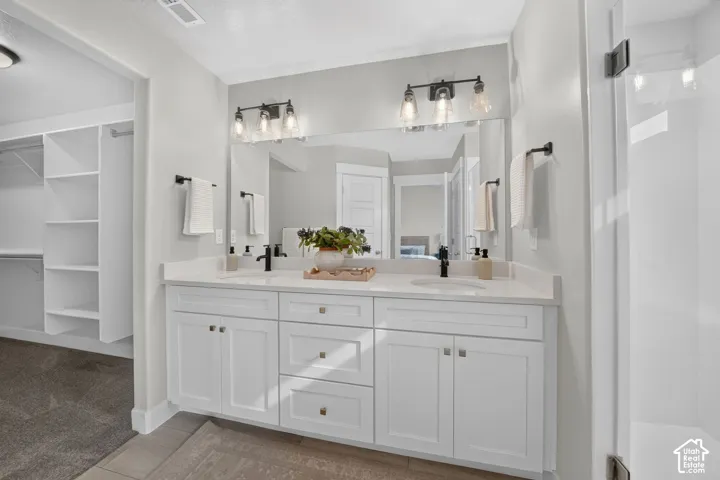 Dual sink vanity with white cabinetry and integrated sinks, complemented by matte black fixtures