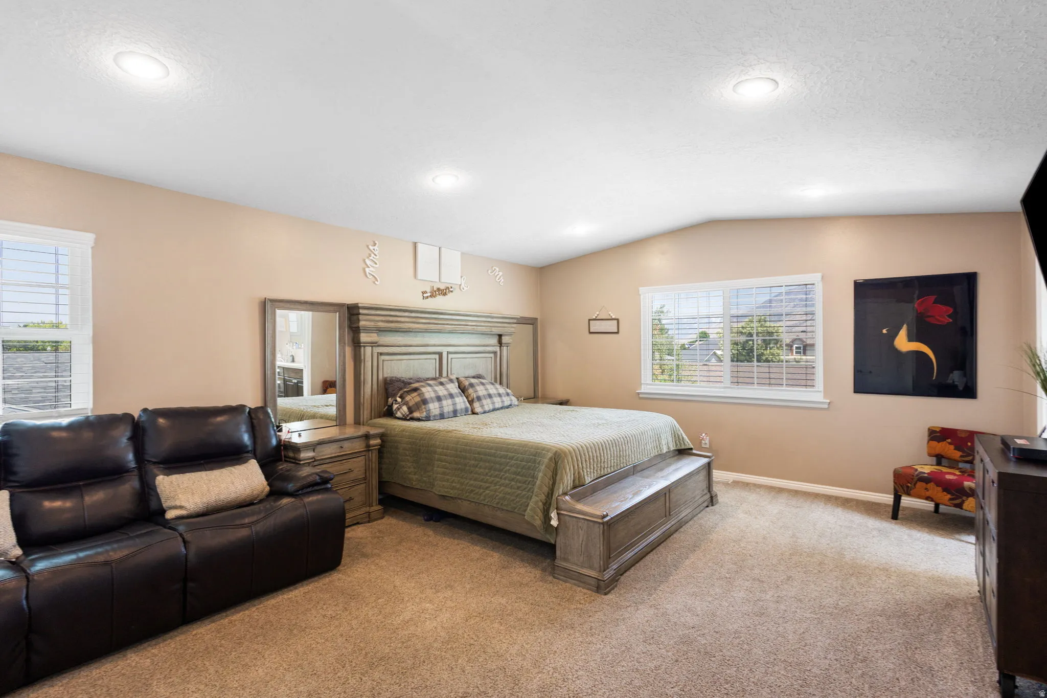 Recessed lighting, sloped ceiling, multiple windows with blinds, and carpeted flooring