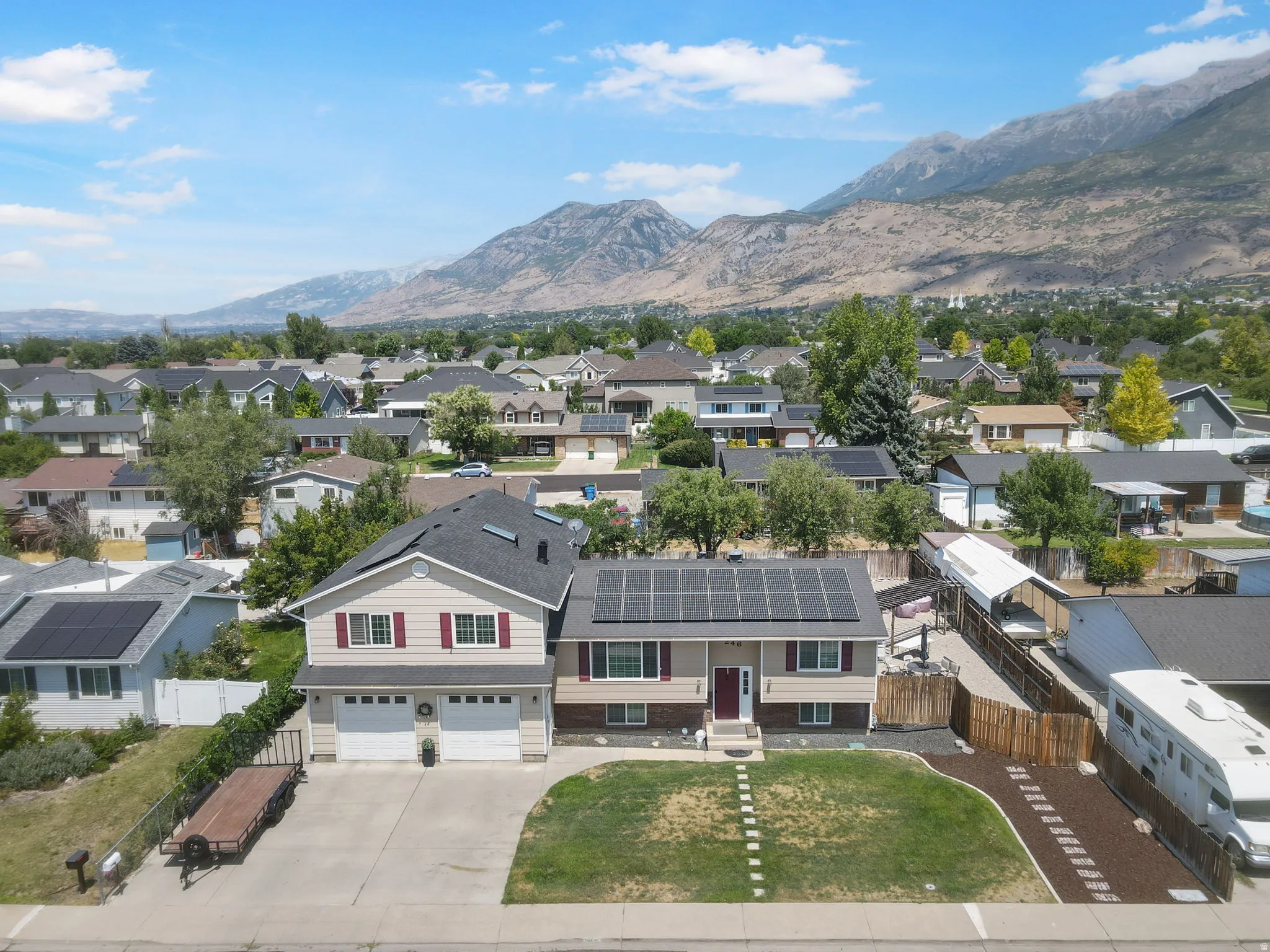 Two-story residence with a two-car garage, solar panels, and a stone facade