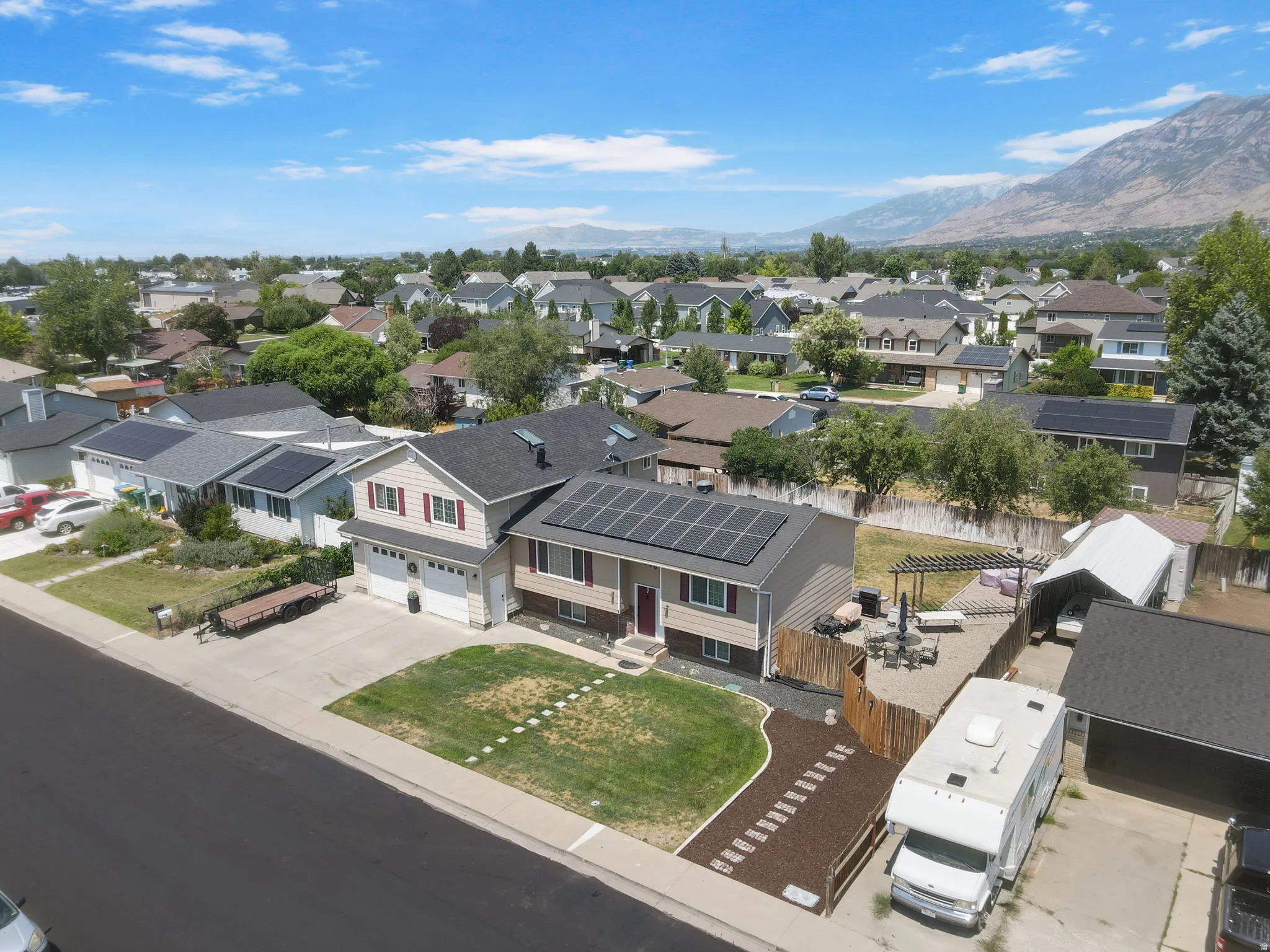 Two-story residence with a two-car garage, front lawn, and rear hardscape patio