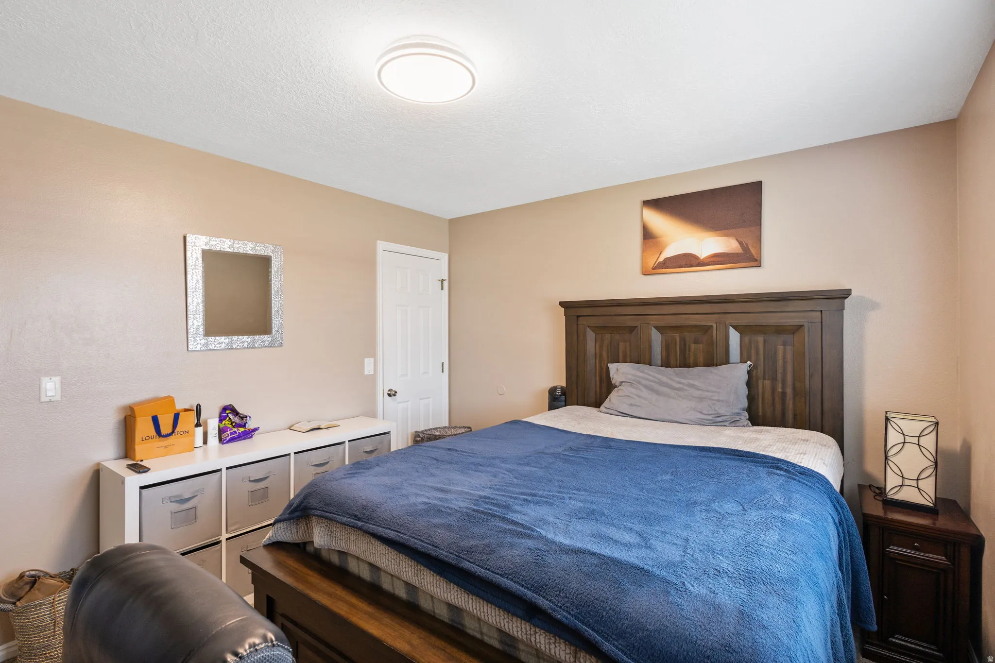 Warm neutral wall paint, overhead flush-mount lighting, and a paneled white door