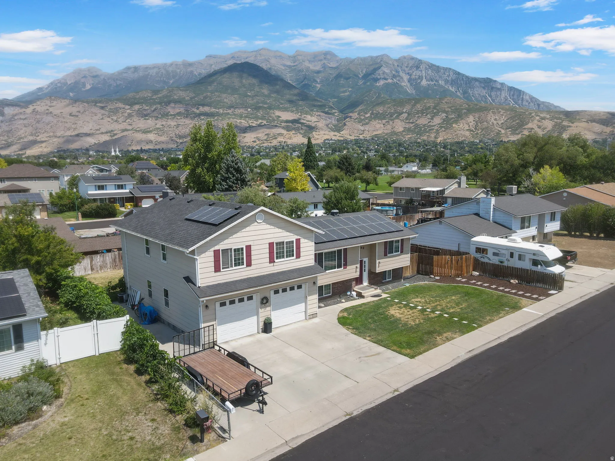Two-story residence with a two-car garage, solar panels, and a concrete driveway