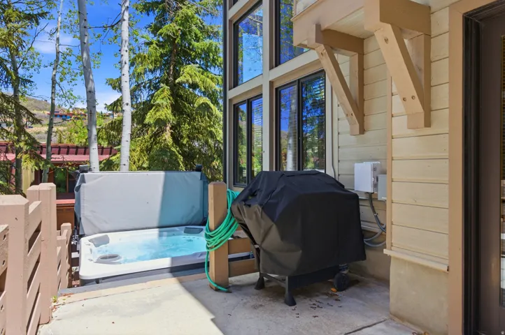 Outdoor patio with a built-in hot tub, high ceilings, and extensive window-line