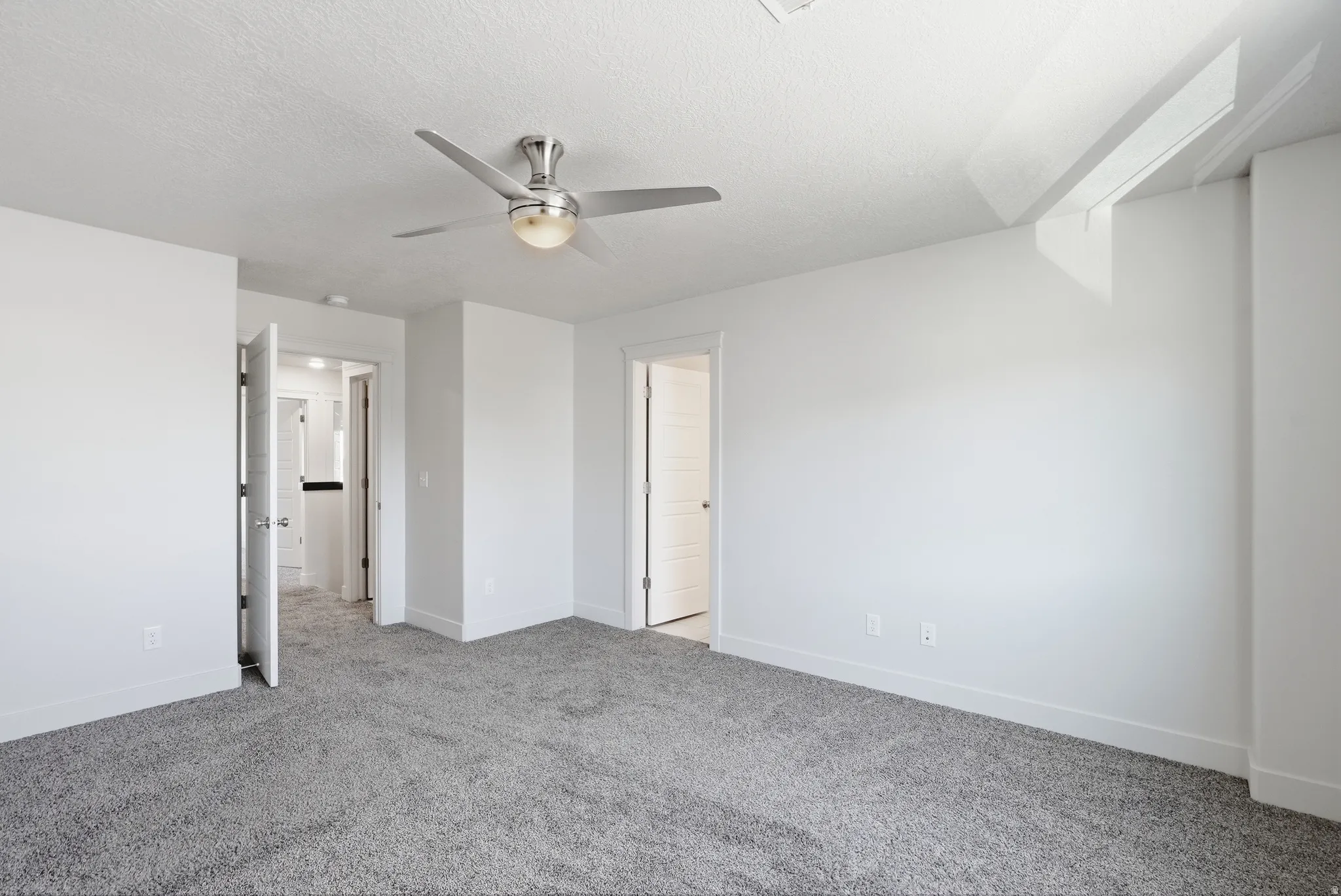 Recessed ceiling fan with integrated lighting, textured ceiling, gray carpet flooring, white walls, and white trim