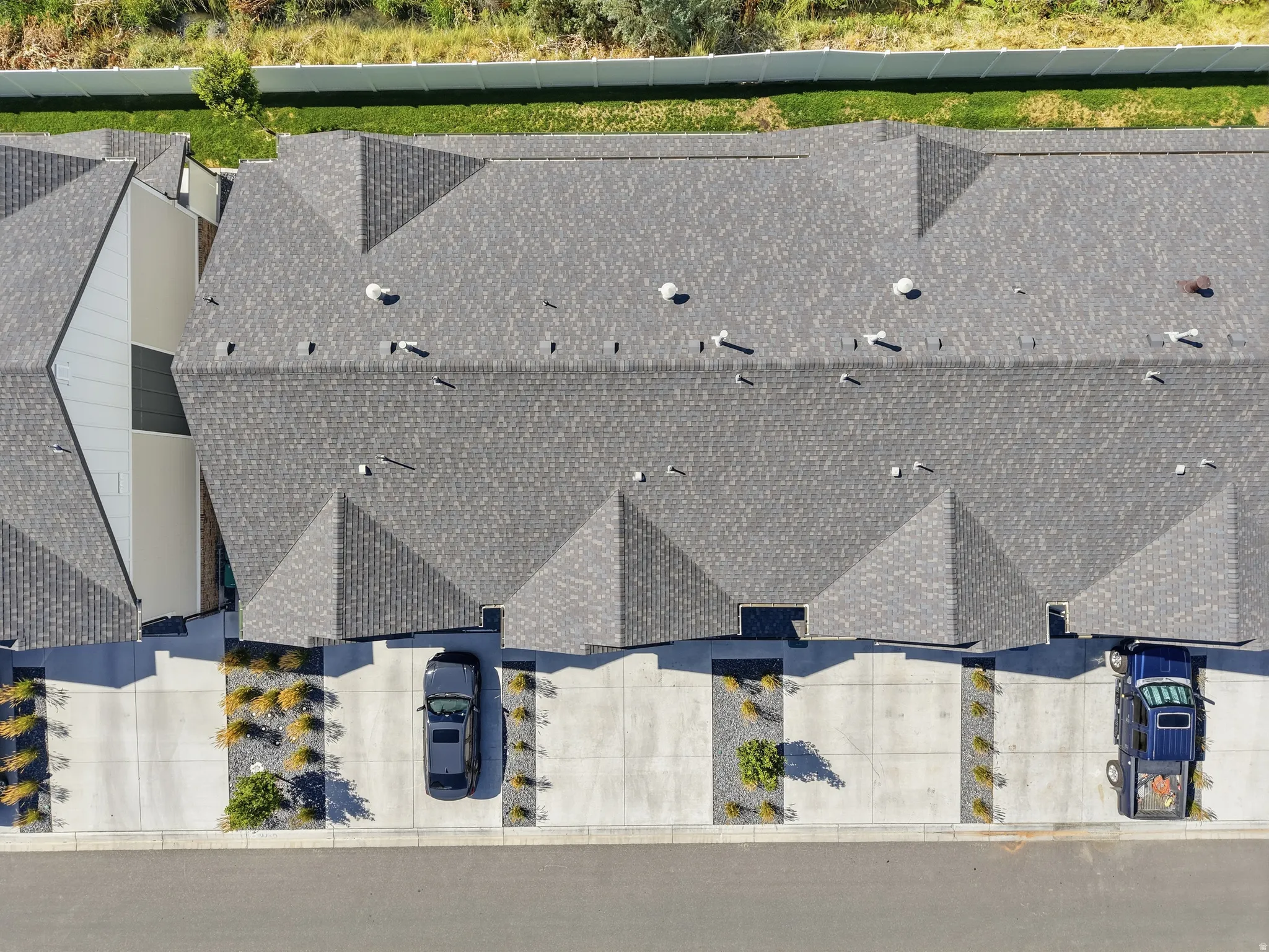 Asphalt shingle roofing, concrete driveways, and landscaped rock beds