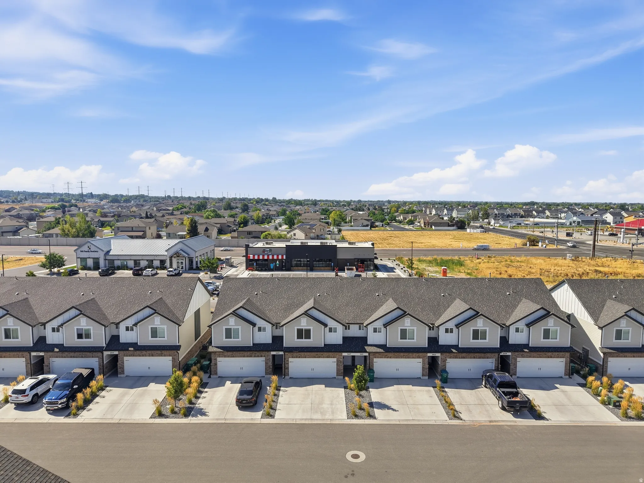Attached multi-unit residences featuring individual garages and paved driveways