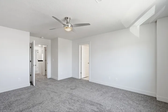 Recessed ceiling fan with integrated lighting, textured ceiling, gray carpet flooring, white walls, and white trim