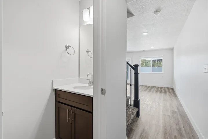 Vanity with a white countertop and integrated sink, chrome faucet, and rectangular mirror