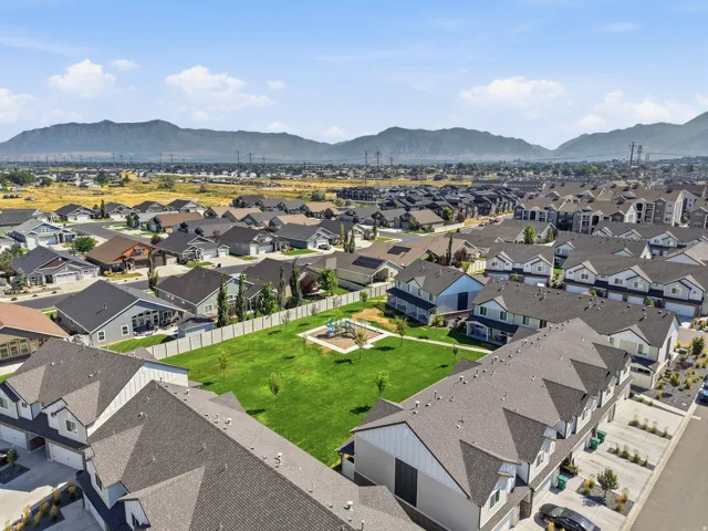 Residential community featuring a central green space, playground, and mountain backdrop