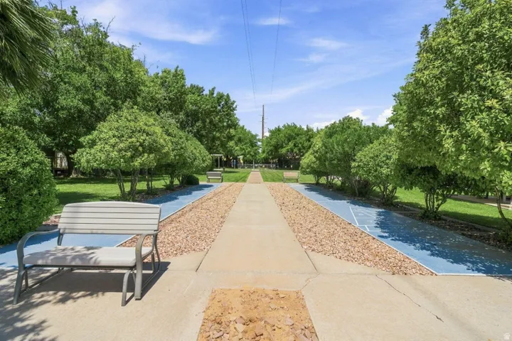 Landscaped grounds with a concrete pathway, gravel borders, and mature trees