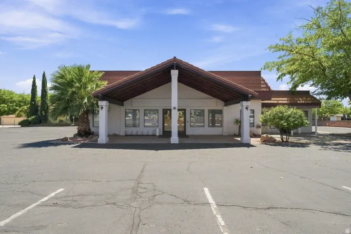 Building exterior with a terracotta-style tile roof, multiple white support columns, and visible window openings