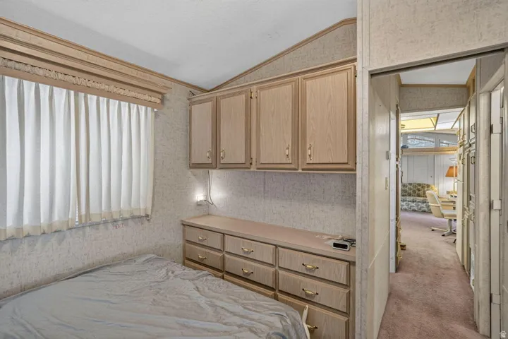 Integrated built-in cabinetry, upper storage cabinets, lower storage drawers, and a window with privacy coverings