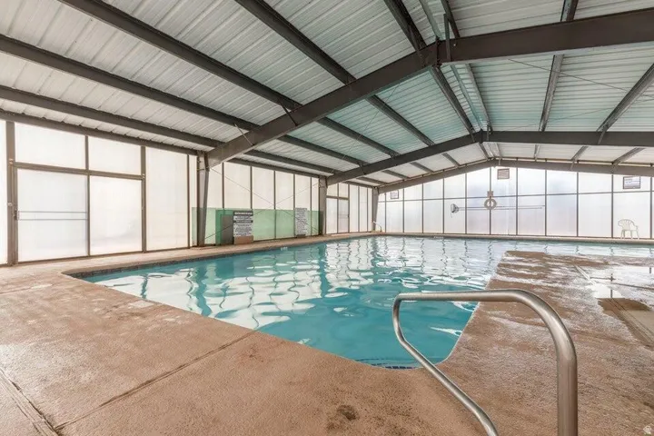 Enclosed indoor swimming pool with a metal roof and exposed structural beams