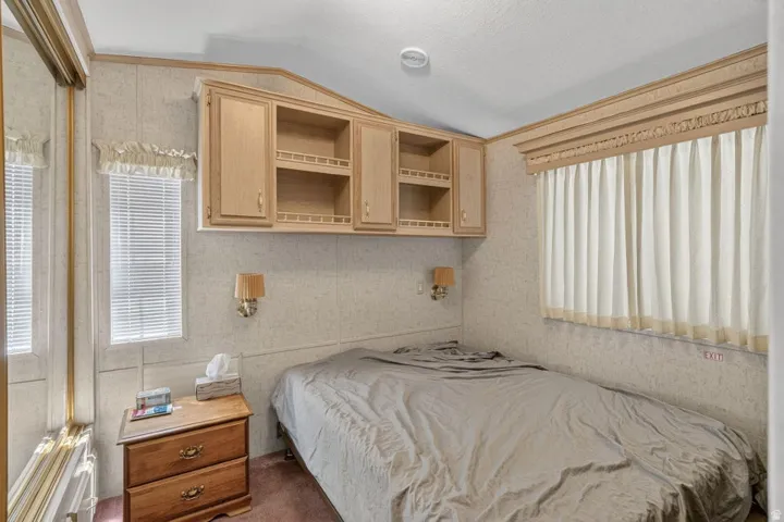 Built-in storage cabinetry, two wall-mounted sconces, and overhead lighting
